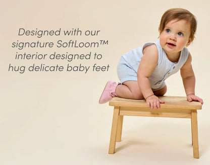 Baby on bench wearing Ten Little Everyday Baby Booties designed with signature SoftLoom™ interior designed to hug delicate baby feet - Soft Pink. Available at www.tenlittle.com