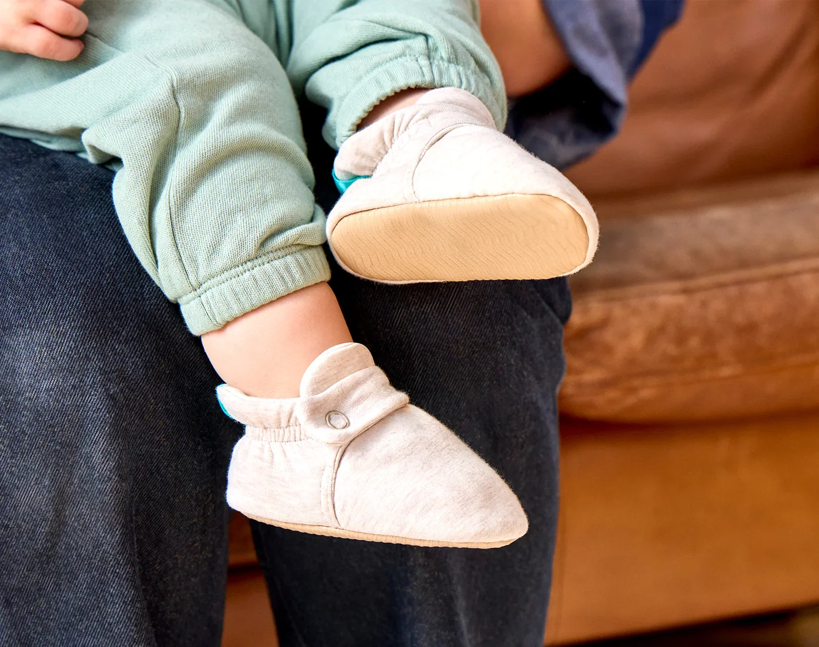 Side and bottom grippy outsole view and baby wearing Ten Little Everyday Baby Booties - Heather Oat. Available at www.tenlittle.com
