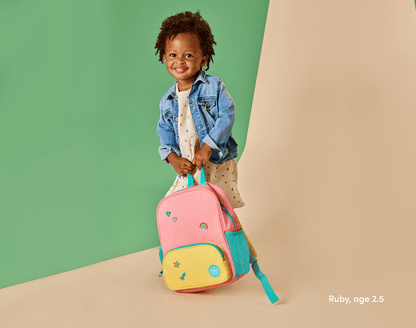 Girl age 2.5 holding Ten Little Recycled Backpack 12 Inch - Pink & Yellow. Available at www.tenlittle.com