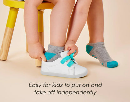 Child putting on Ten Little Everyday Original - Simply White. Available at www.tenlittle.com