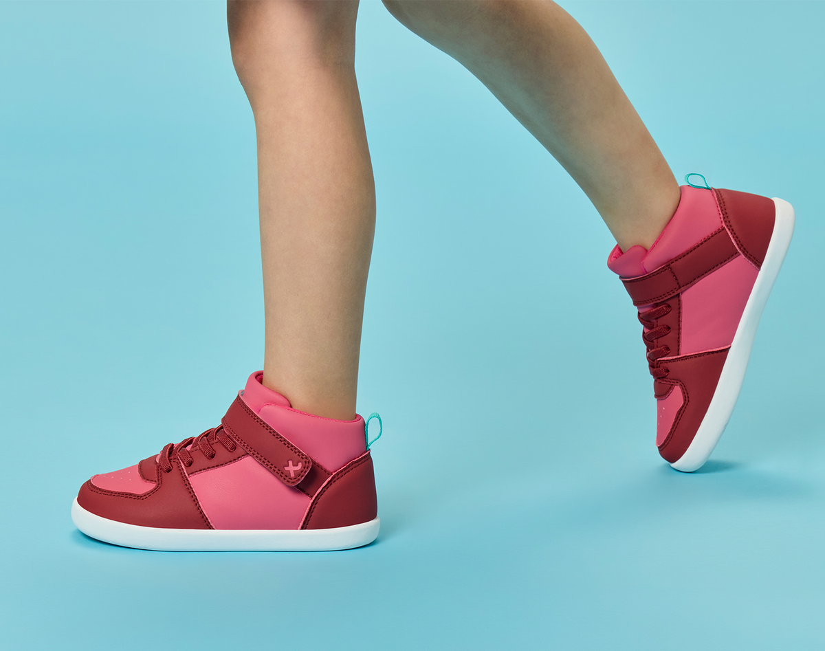 Side view child wearing Ten Little Varsity Mid Tops - All Star Pink. Available at www.tenlittle.com