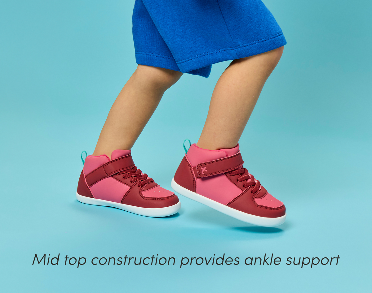 Side view child wearing Ten Little Varsity Mid Tops featuring ankle support - All Star Pink. Available at www.tenlittle.com