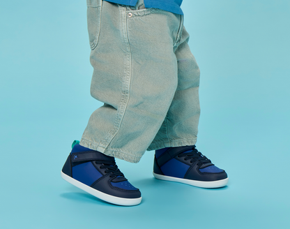Side view child wearing Ten Little Varsity Mid Tops - Game Day Blue. Available at www.tenlittle.com