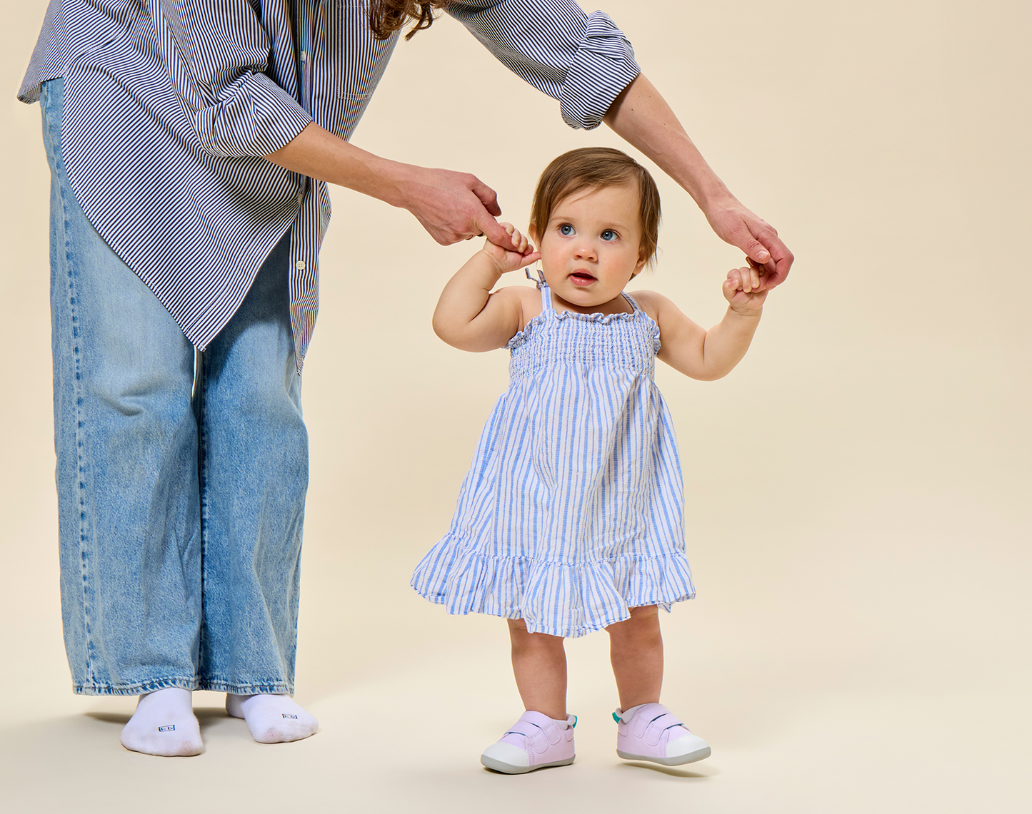Mom helping child walk wearing Ten Little First Walkers - Lavender Purple. Available at www.tenlittle.com