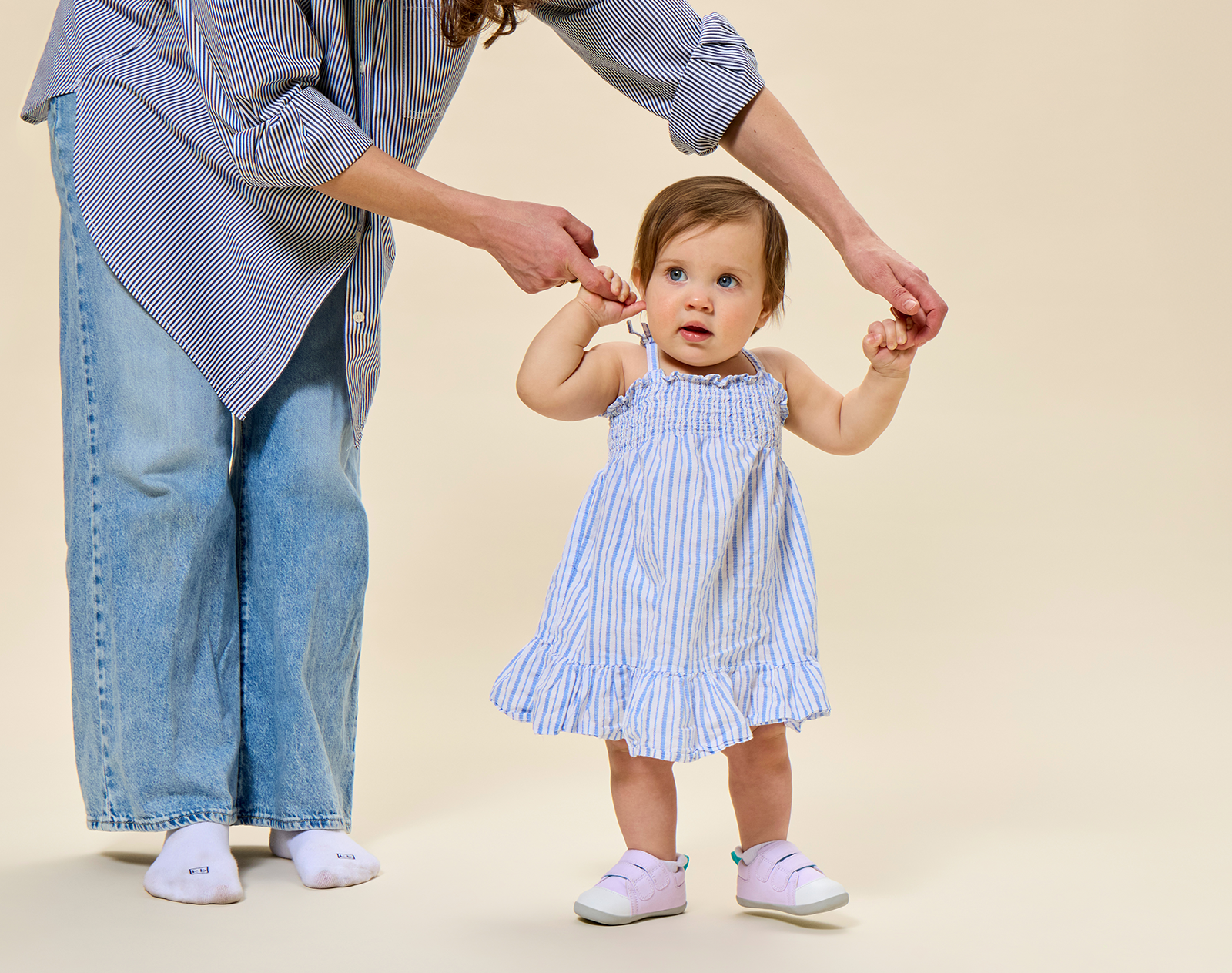 Mom helping child walk wearing Ten Little First Walkers - Lavender Purple. Available at www.tenlittle.com
