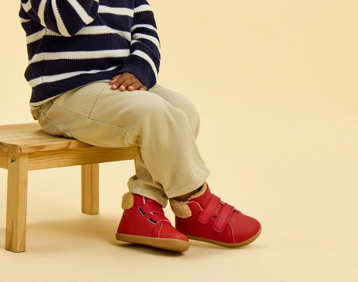 Child sitting wearing Ten Little Furry High Tops - Lava Red. Available at www.tenlittle.com
