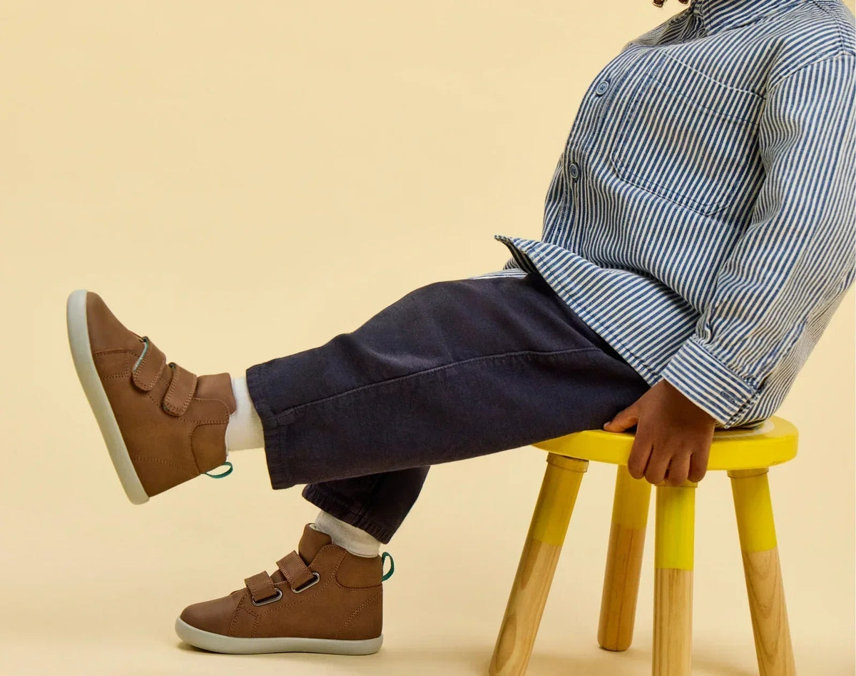 Child sitting wearing Ten Little Everyday High Tops - Mocha Brown. Available at www.tenlittle.com