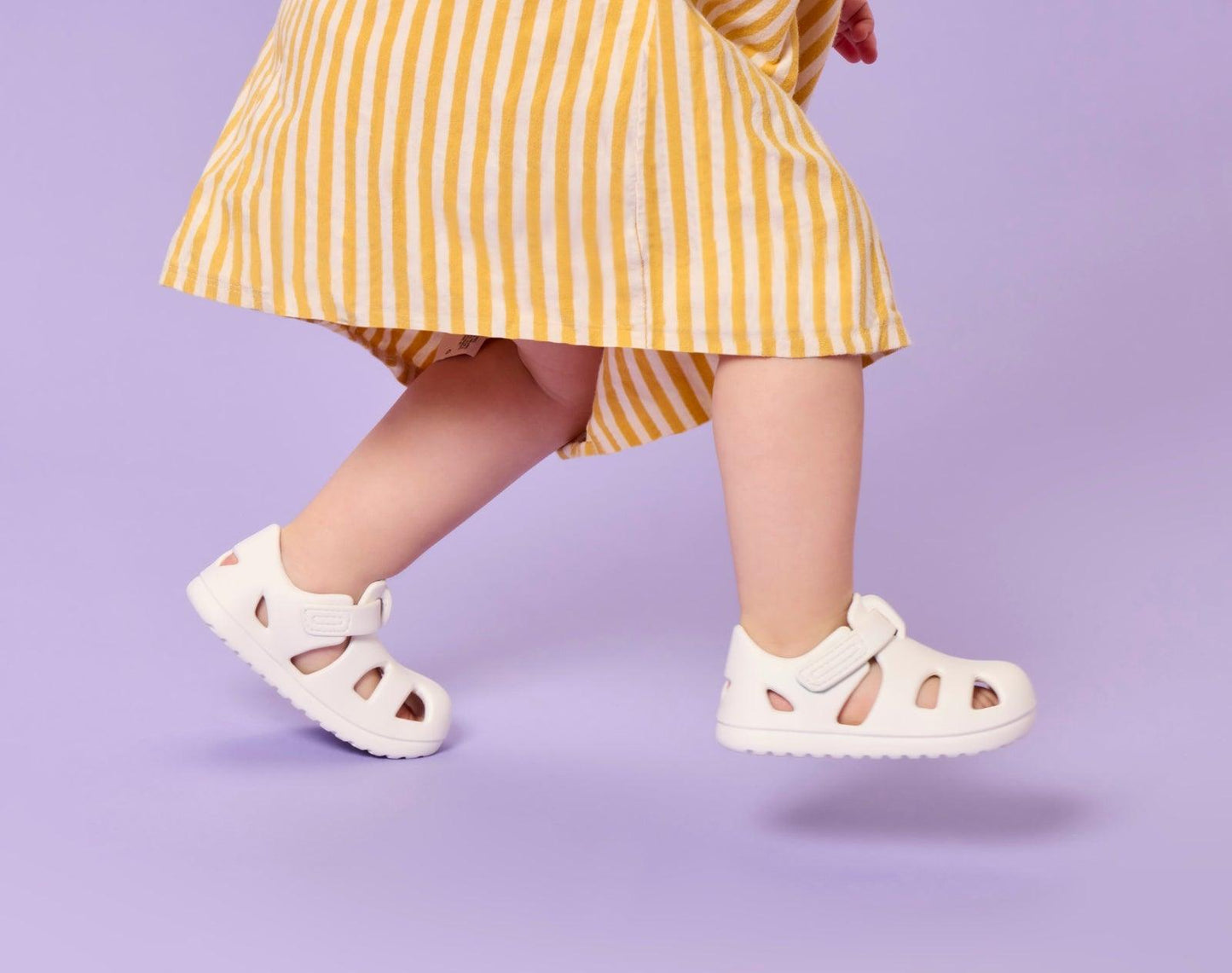 Side view of child wearing Ten Little Splash Sandals - Soft White. Available at www.tenlittle.com