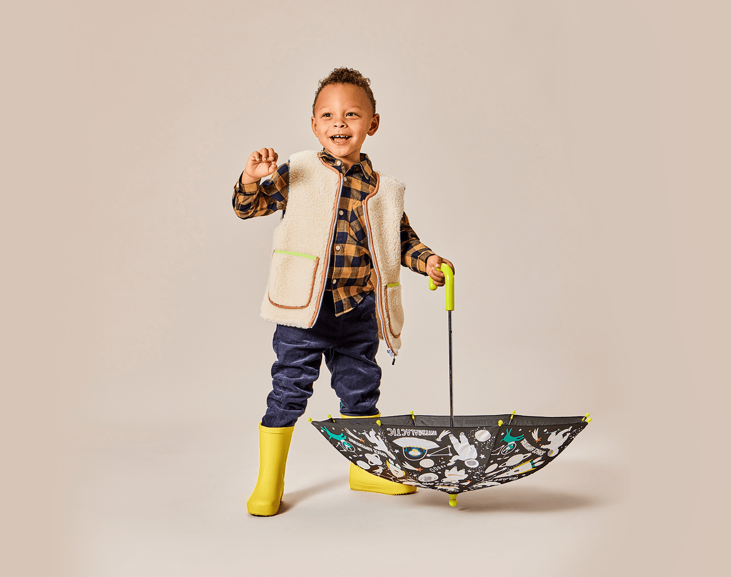 Boy holding umbrella wearing Ten Little Rain Boots - Yellow. Available at www.tenlittle.com